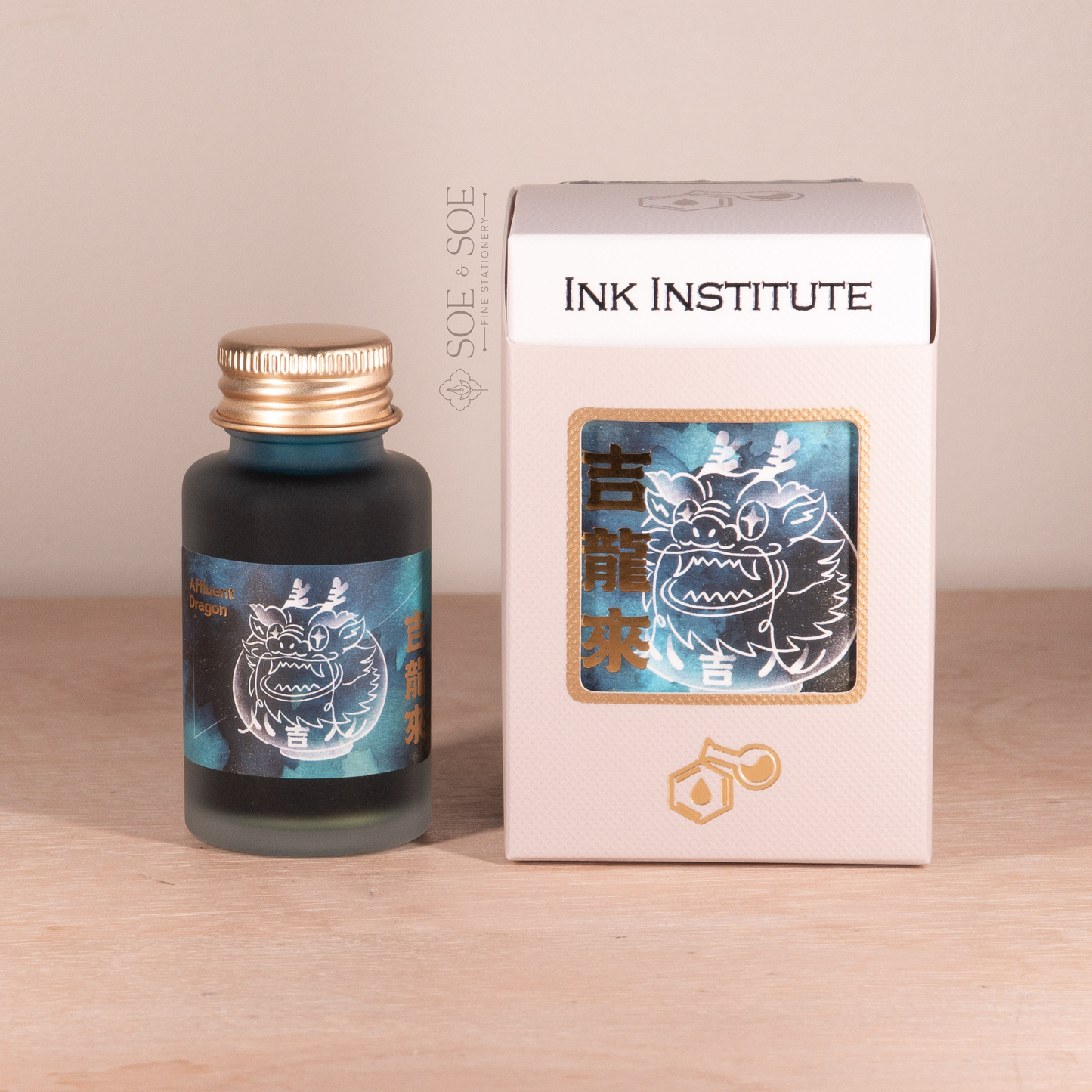 Ink bottle and packaging with 'Ink Institute' branding on a wooden surface.