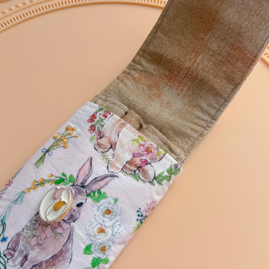 Open fabric pen case with bunny and flower pattern on a beige background