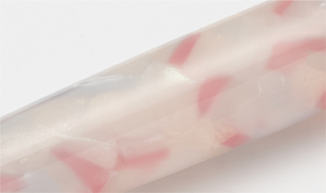 Close-up of a pink and white cylindrical object on a light gray background