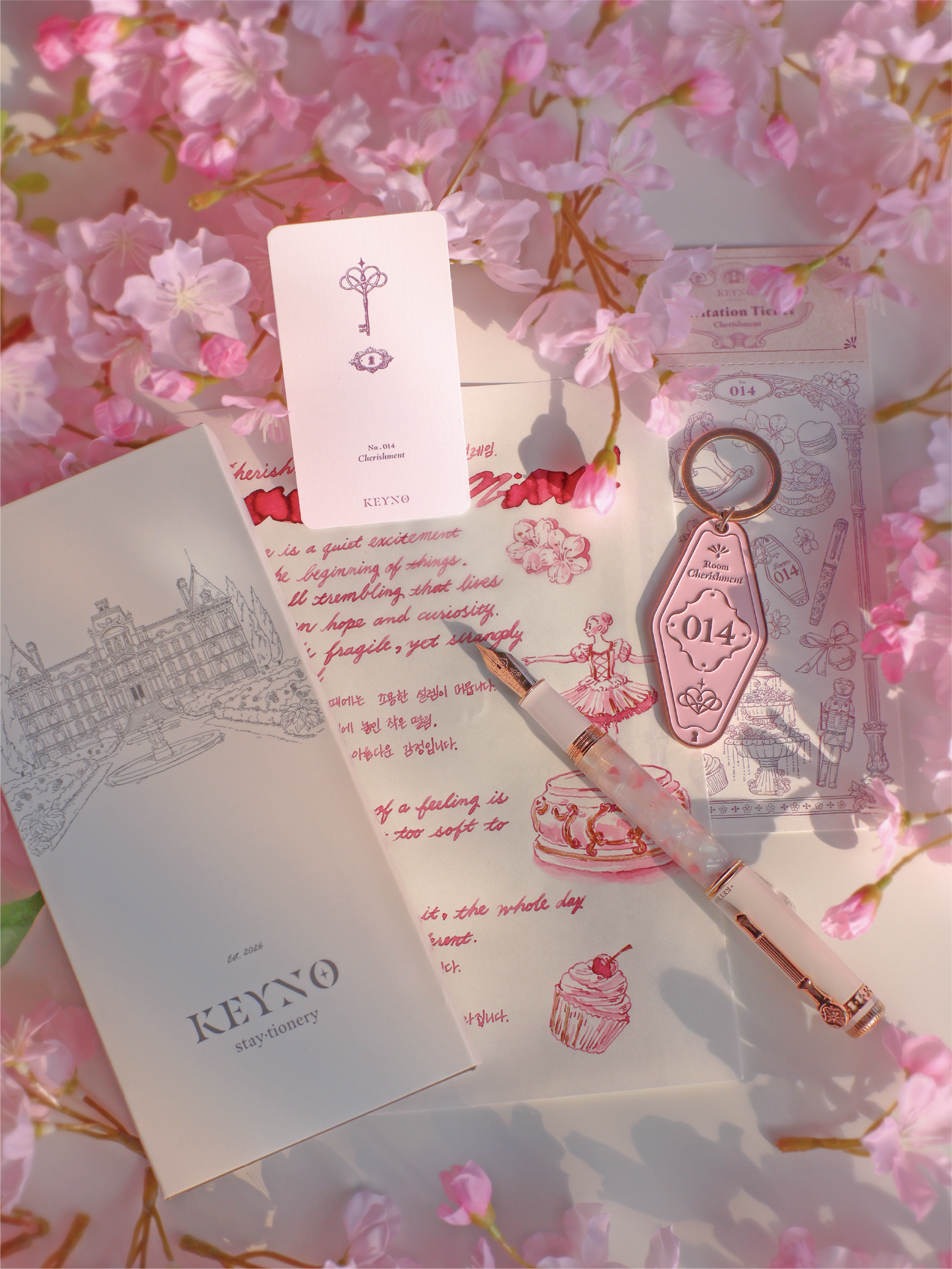 Stationery items including a pen, notebook, and keychain on a floral background