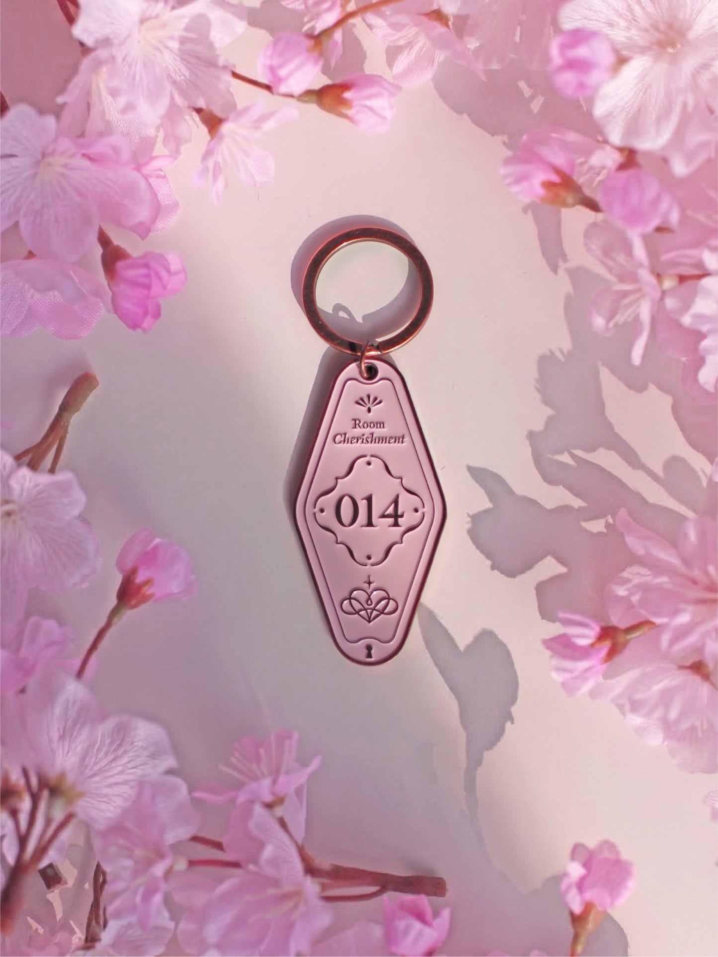 Pink key-shaped object with '014' on a pink floral background
