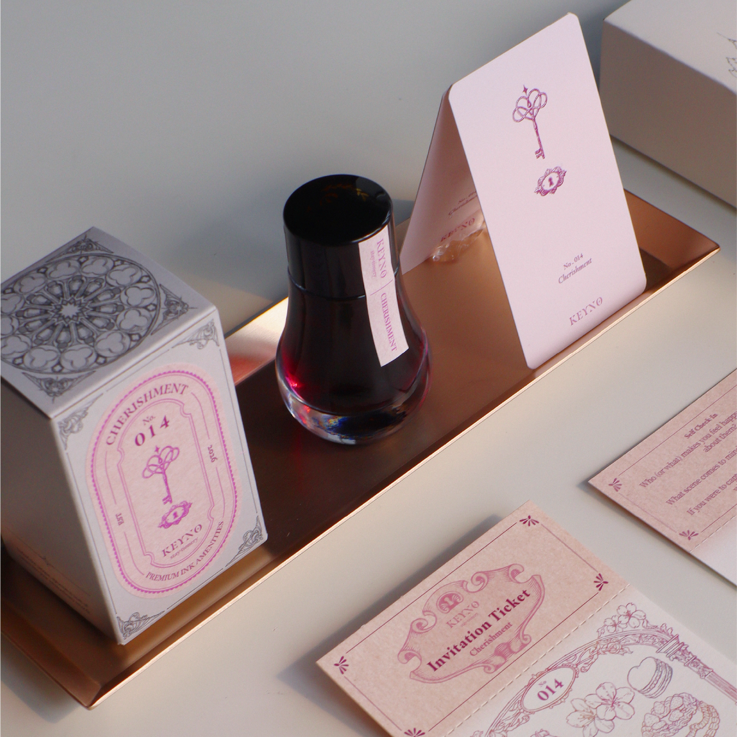 Ink bottle with decorative packaging and cards on a white table