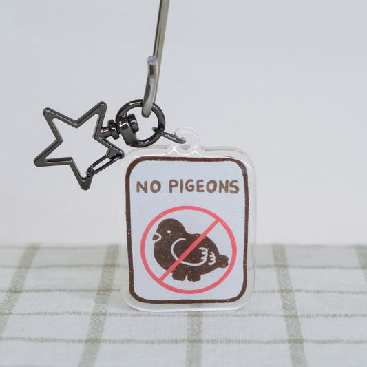 Keychain with 'No Pigeons' sign on a white background