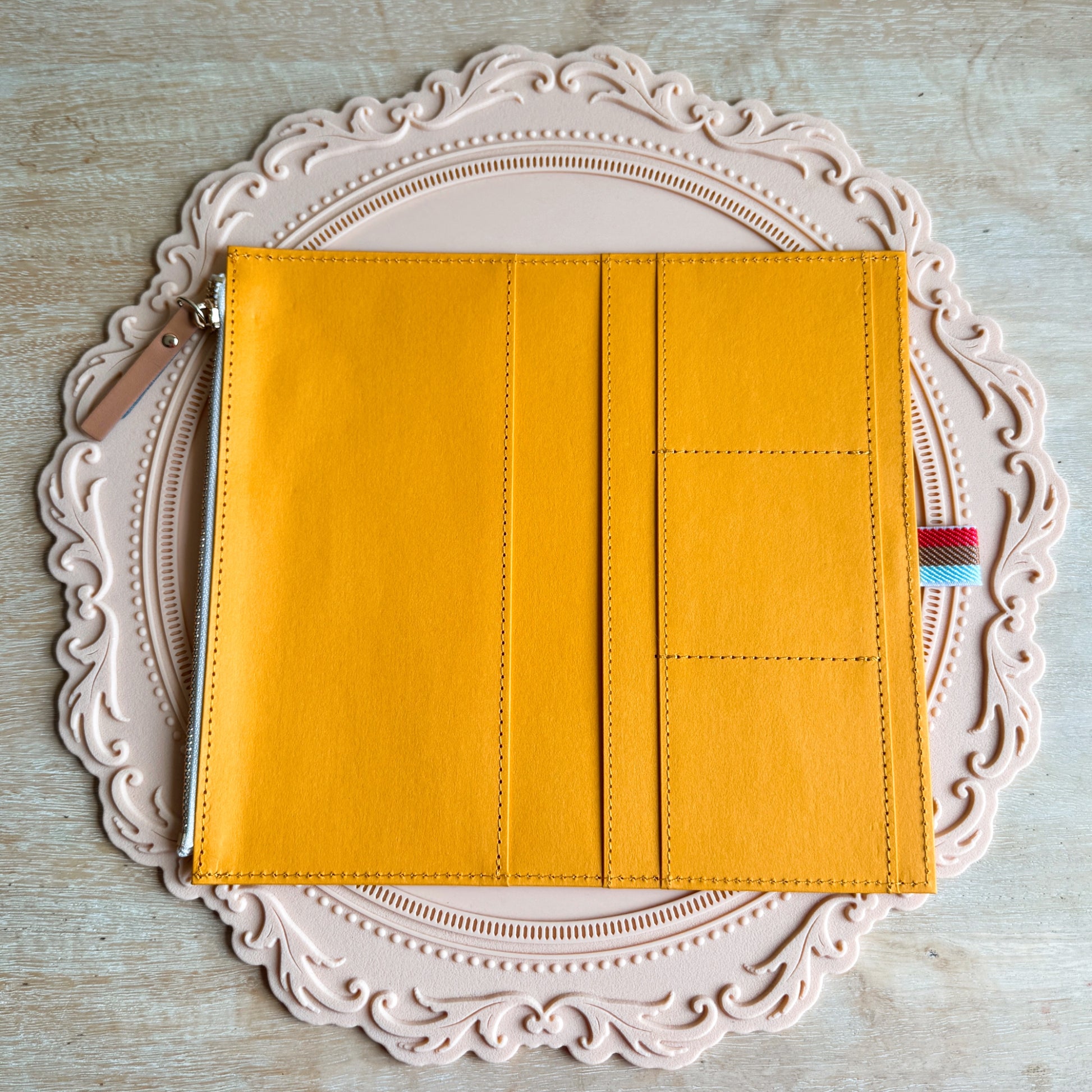 Yellow pouch with a zipper on a decorative white plate
