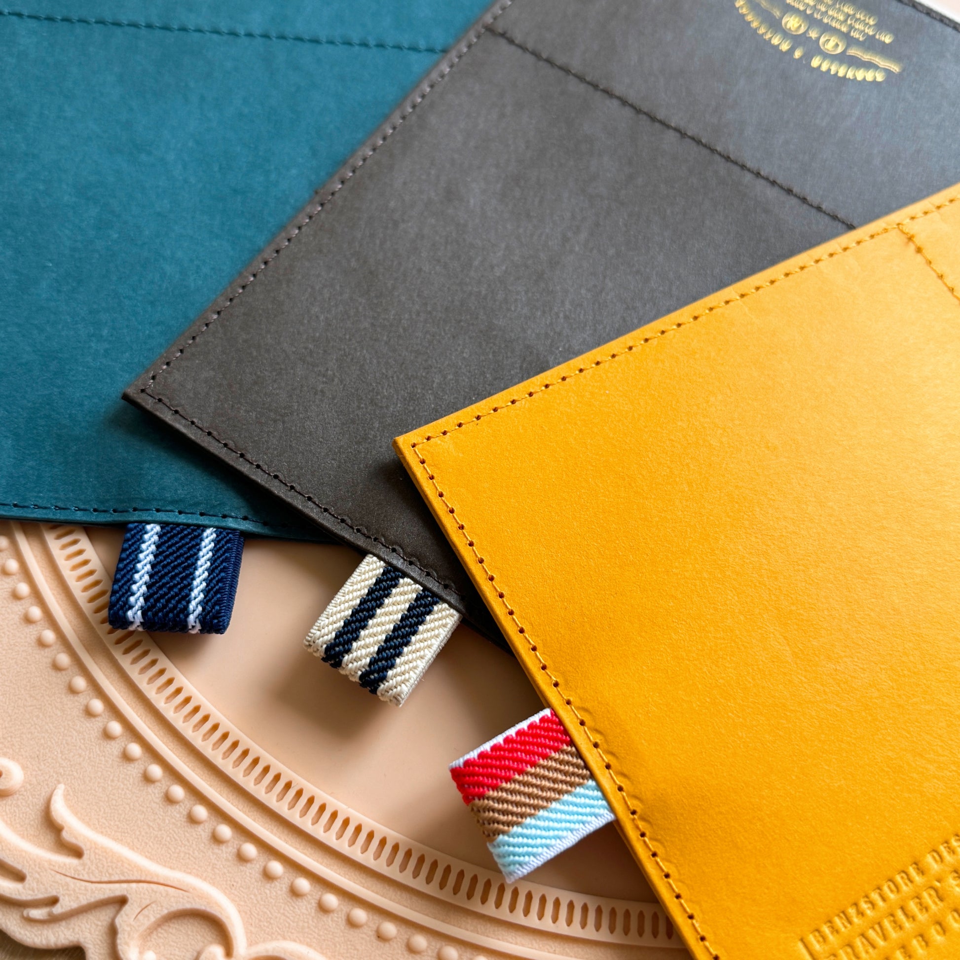 Three fabric swatches in blue, gray, and yellow on a decorative plate.