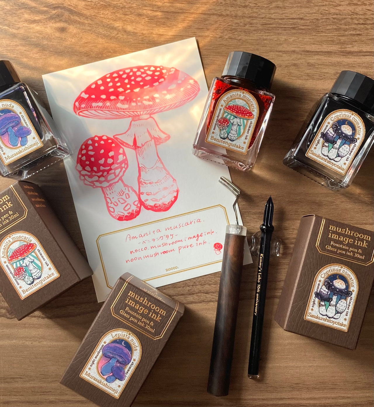 Mushroom-themed ink bottles and packaging on a wooden surface