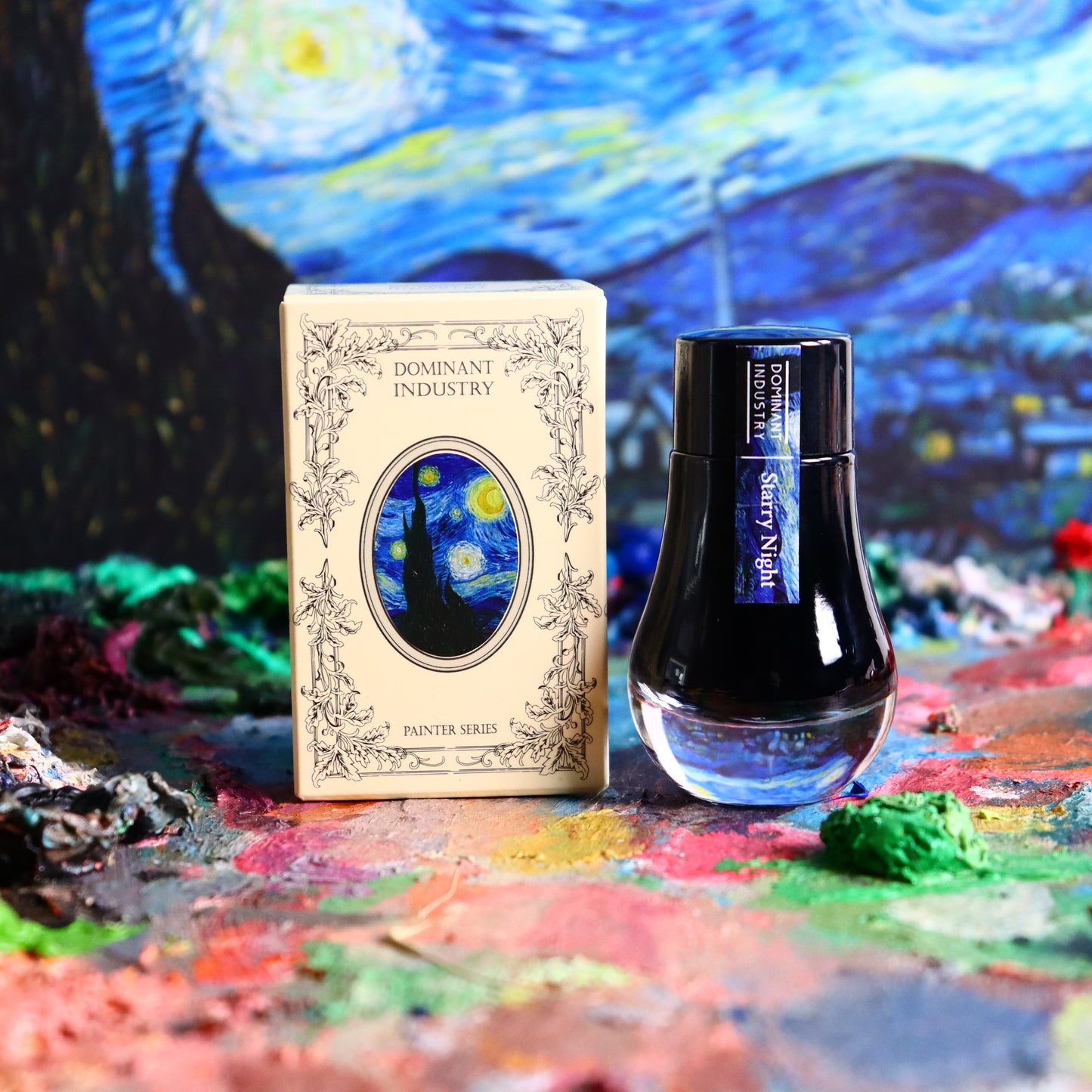 Dominant Industry 'Starry Night' ink bottle and packaging on a colourful, textured surface with Van Gogh's 'Starry Night' painting in the background.