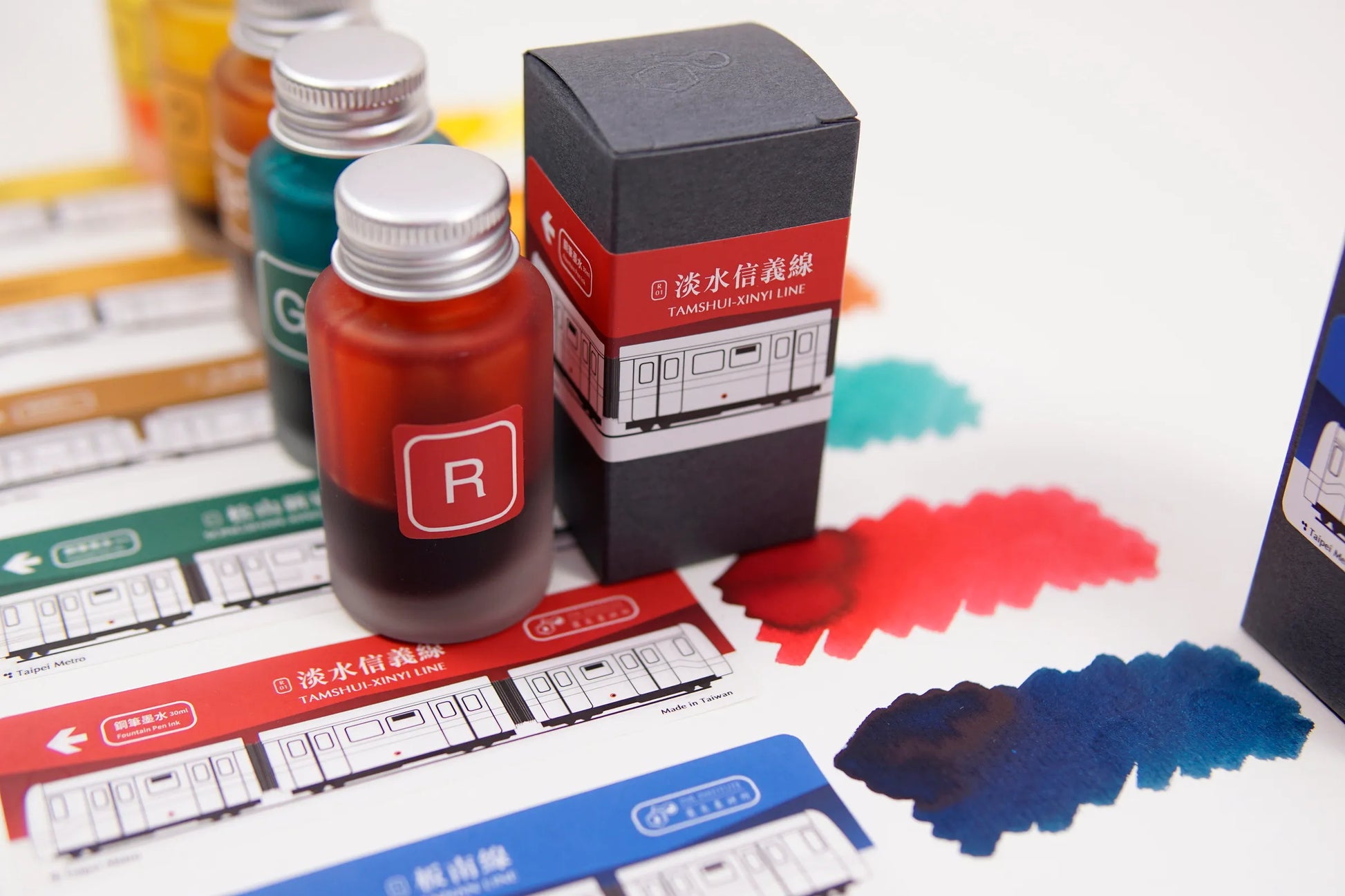 Ink bottle and packaging with ink splashes on a white surface