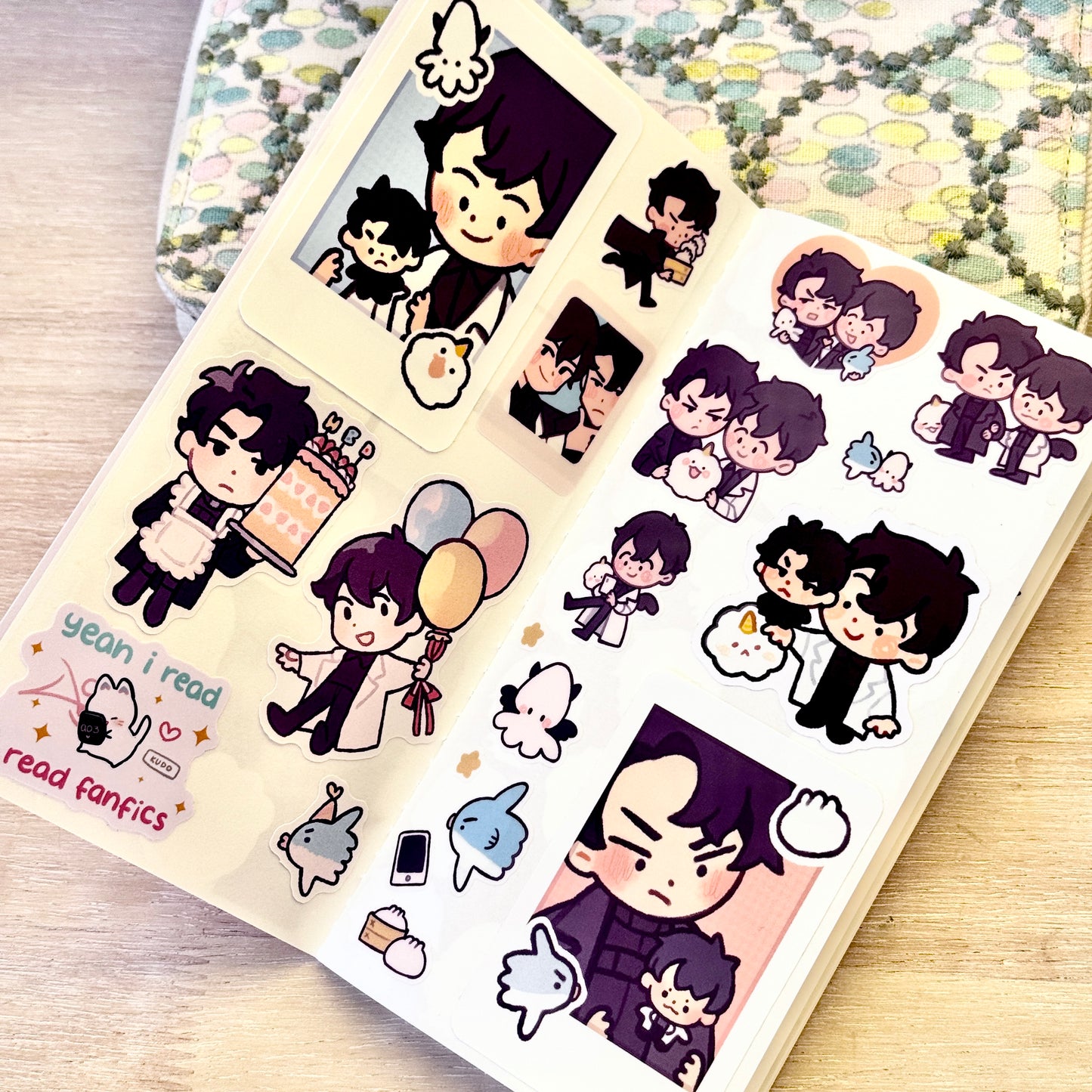 A sheet of cute chibi stickers featuring orv cartoon characters and text reading 'yeah i read read fanfic' on a light wood surface, with a patterned fabric in the background.