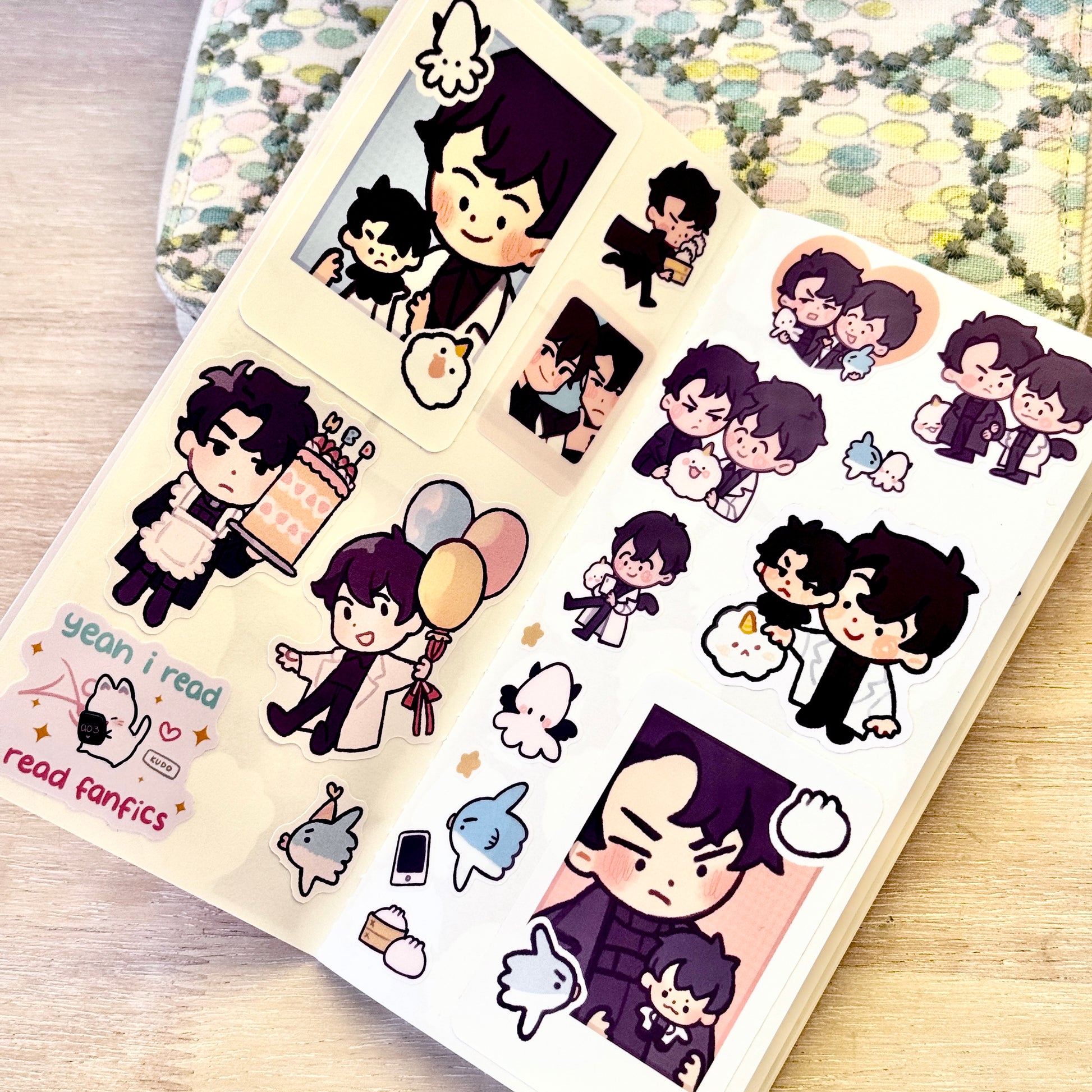 A sheet of cute chibi stickers featuring orv cartoon characters and text reading 'yeah i read read fanfic' on a light wood surface, with a patterned fabric in the background.