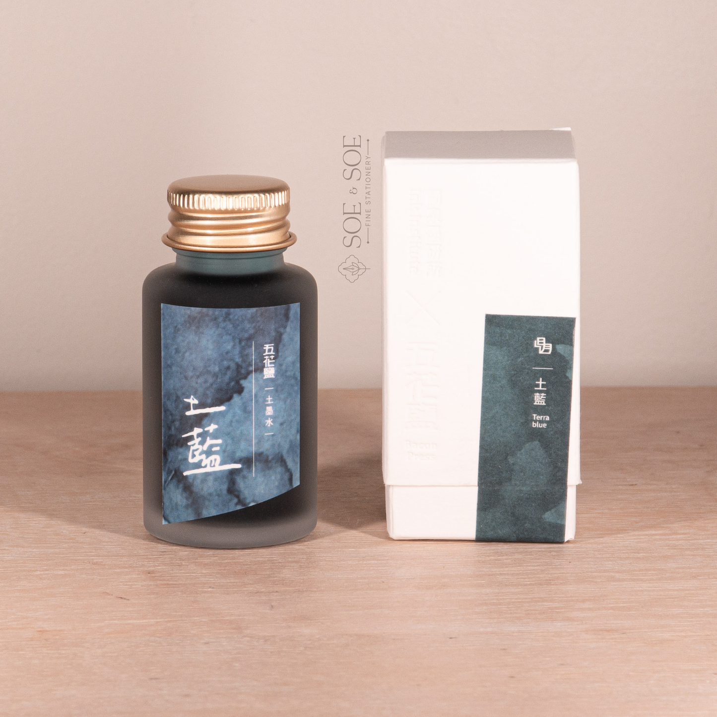 Bottle and box with blue label on a wooden surface