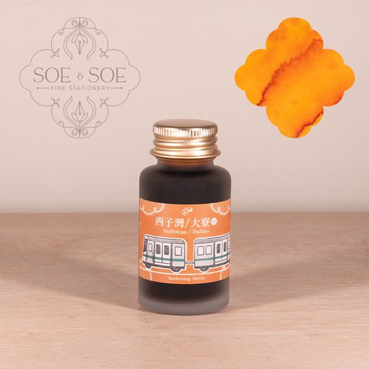 Orange Ink bottle with orange label featuring a train design on a wooden surface, SOE & SOE brand visible.