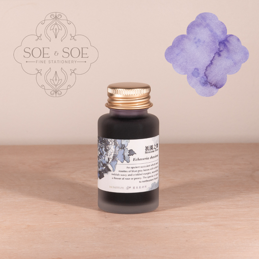 Bottle of ink with a label featuring floral design on a wooden surface, SOE & SOE brand visible.