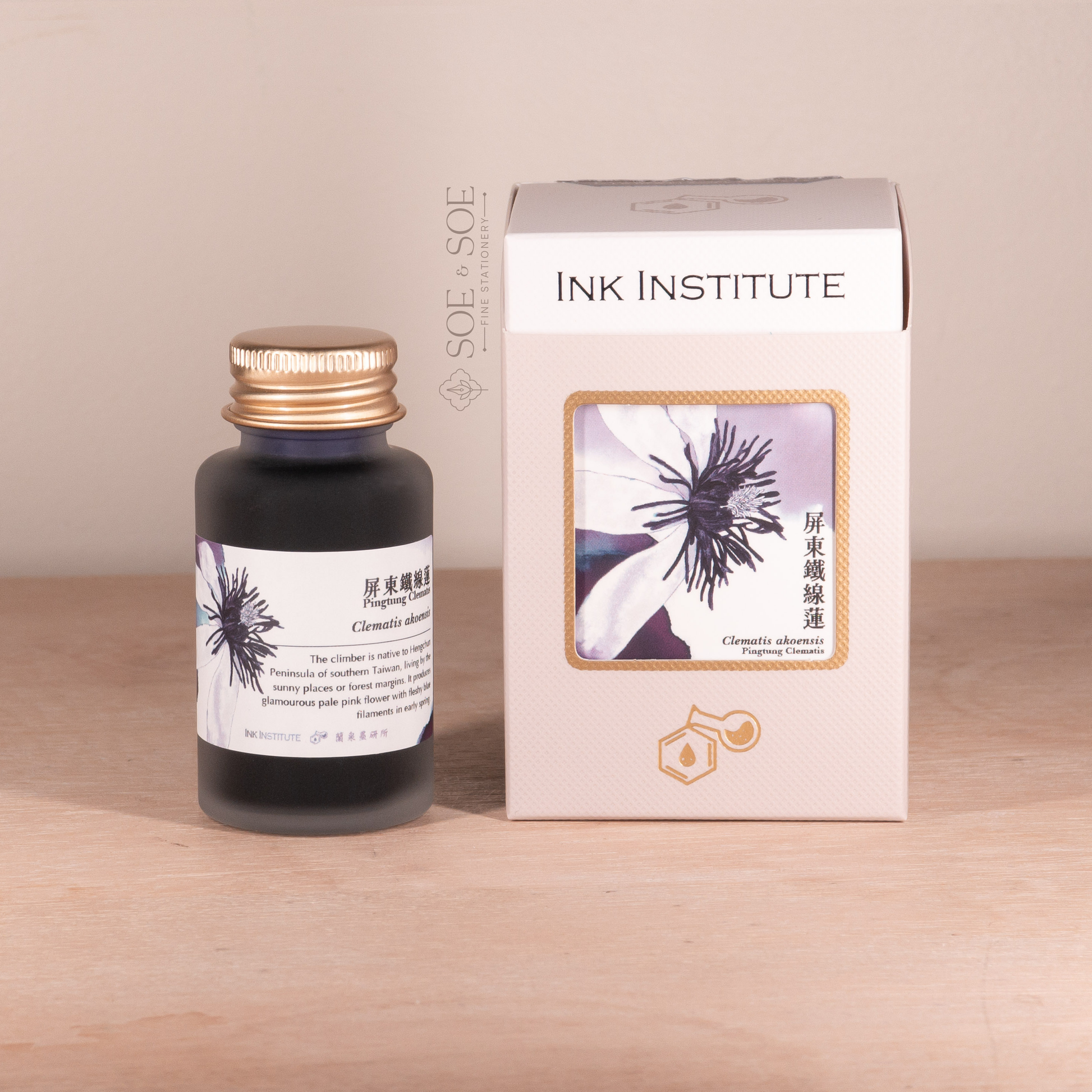 Bottle and box of Ink Institute product on a wooden surface with a beige background
