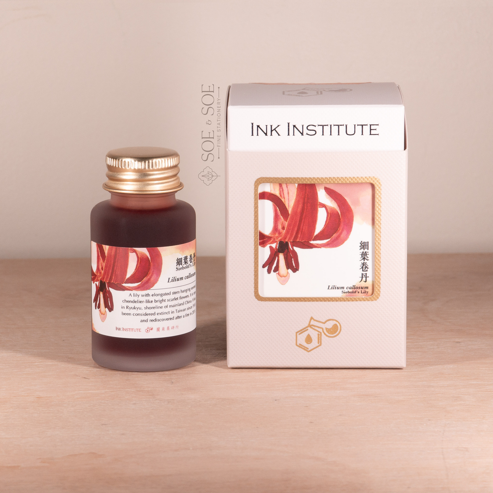 Bottle and box of Ink Institute product on a wooden surface with a beige background