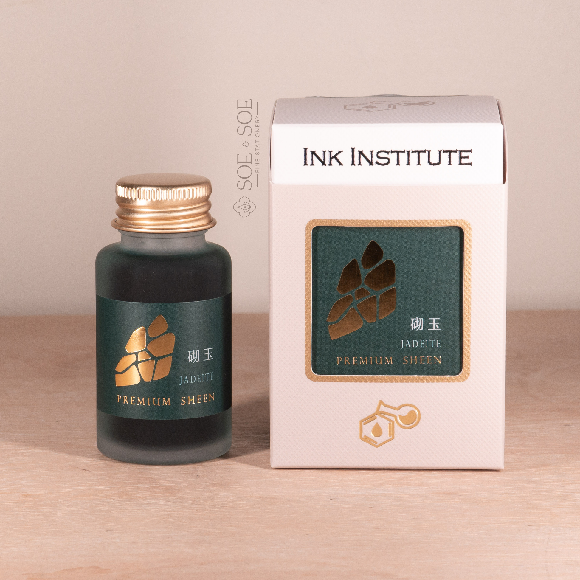 Ink bottle and packaging of Ink Institute on a wooden surface with a beige background