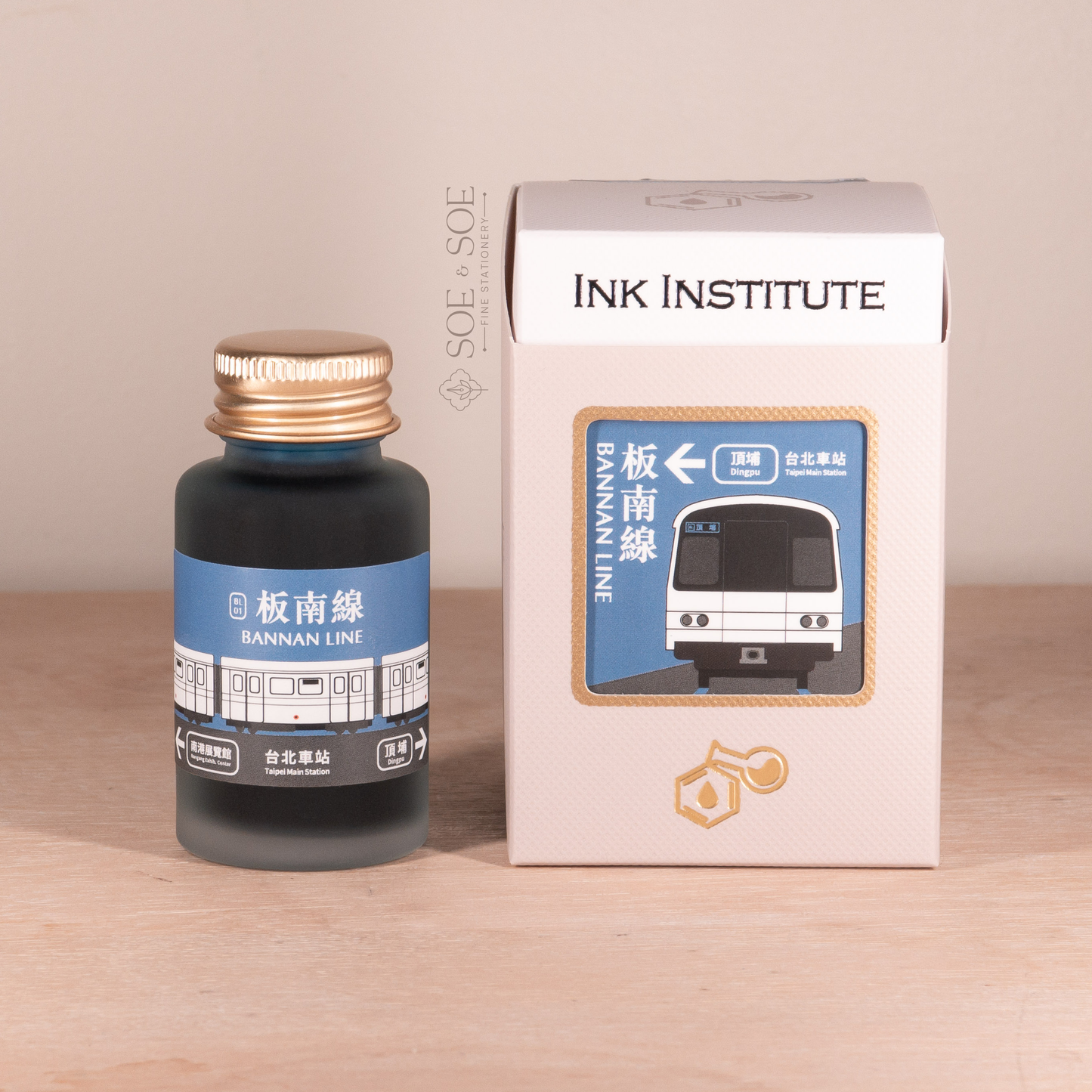 Bottle of Bannan Line ink with a matching box from the Ink Institute on a wooden surface.
