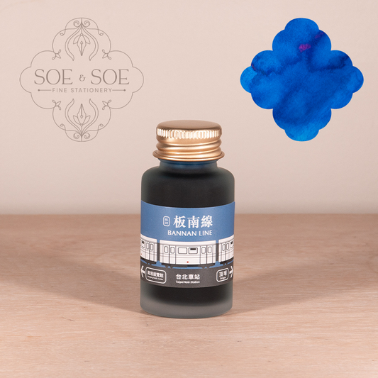 Bottle of Ink Institute Bannan Line  ink with blue label on a wooden surface, featuring the 'SOE & SOE' brand. 