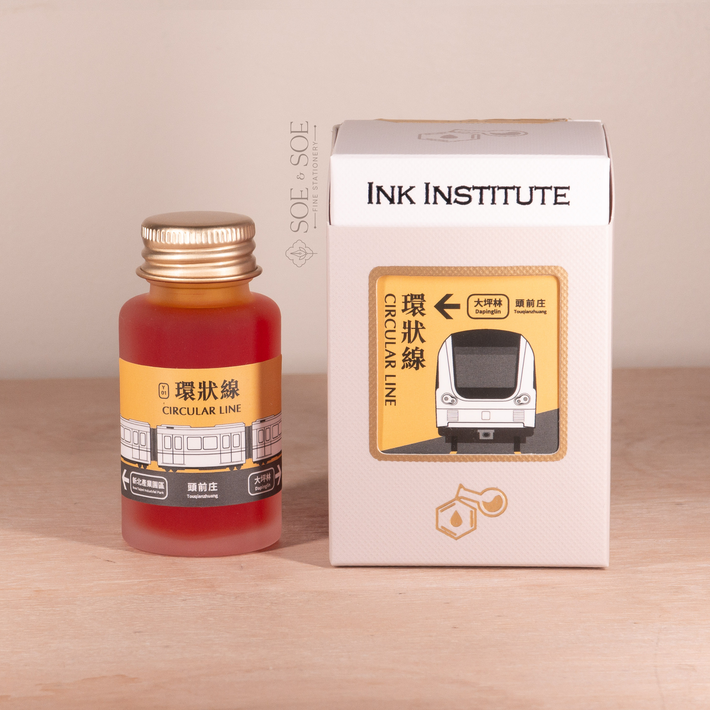Ink bottle and packaging with 'Ink Institute' branding on a wooden background