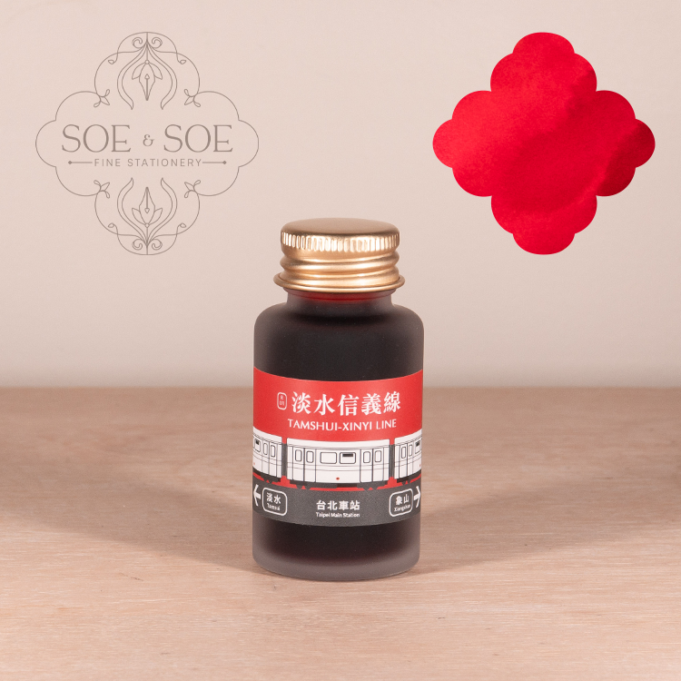 Bottle of Ink Institite ink with a red label on a wooden surface, featuring the 'SOE & SOE' brand.