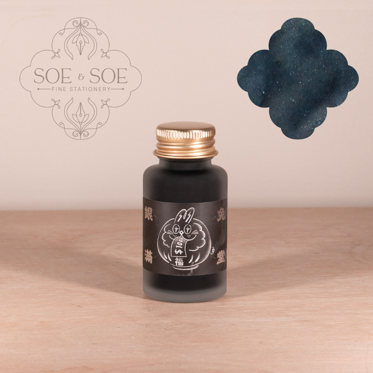 Ink Institute bottle with gold cap and bunny label on a wooden surface, featuring the SOE & SOE logo