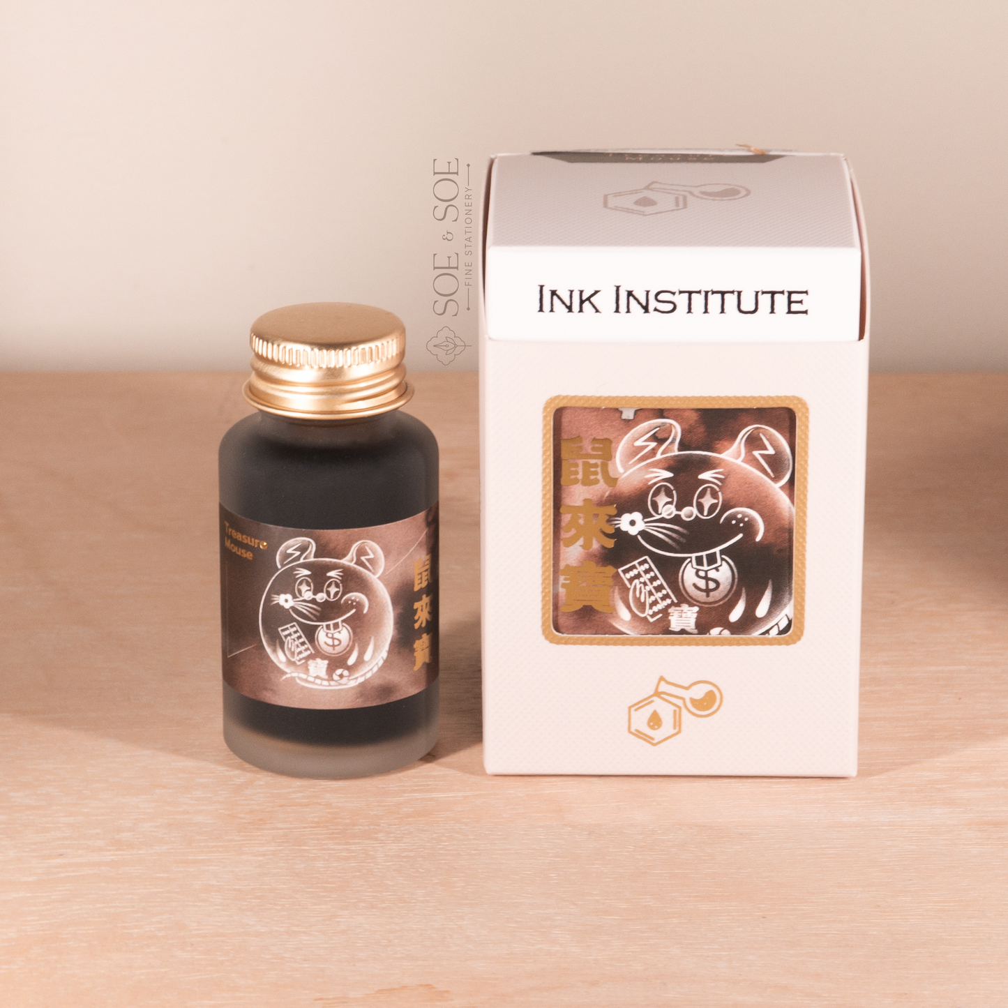 Ink bottle and packaging with 'Ink Institute' branding on a wooden surface.