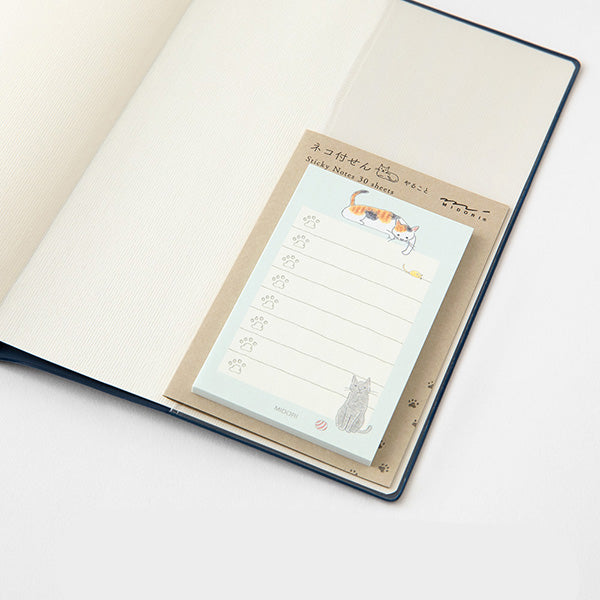 Sheet of cat-themed sticky notes on a notebook