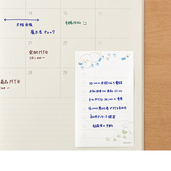 Calendar with handwritten notes and a post-it-note attached to a wooden surface.