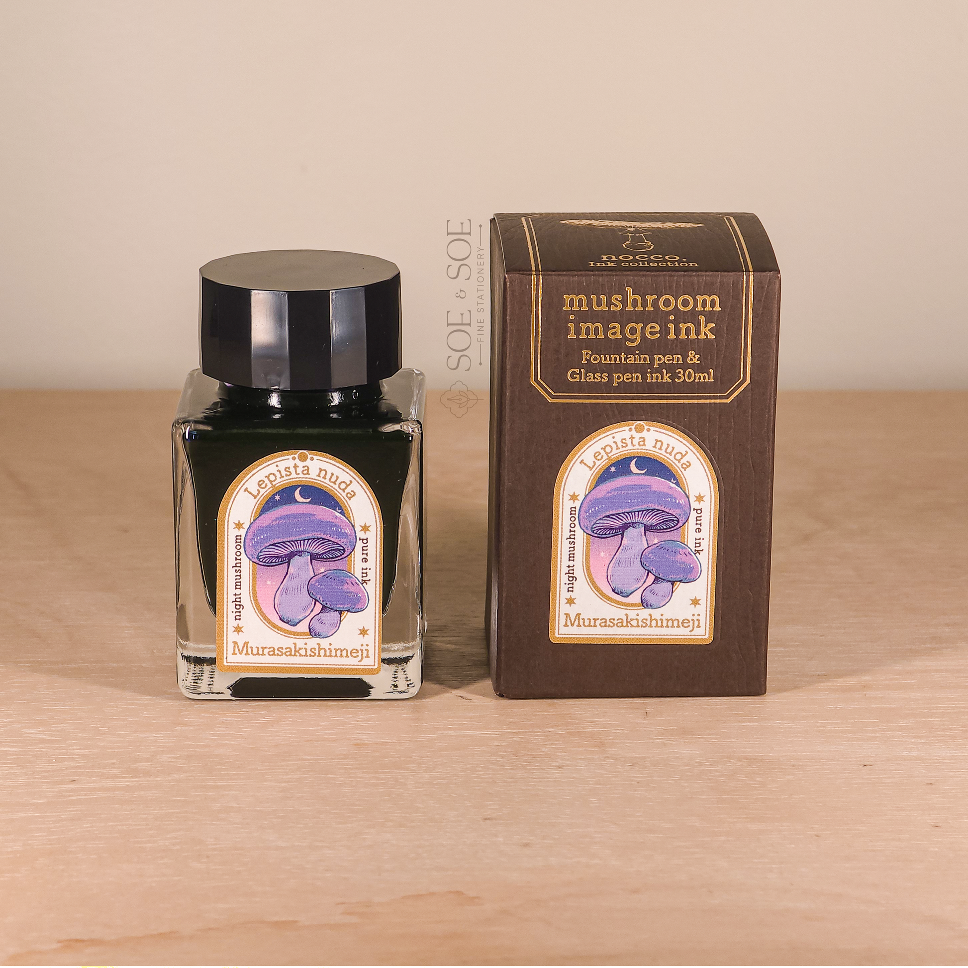 Mushroom image ink bottle and packaging on a wooden surface