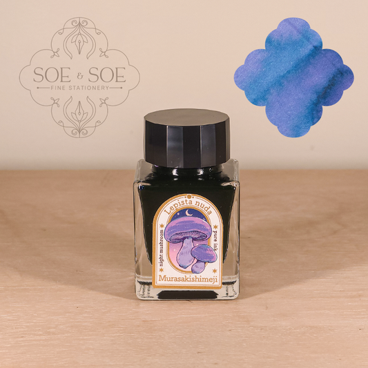Bottle of ink with a purple mushroom label on a wooden surface, featuring the 'SOE & SOE' brand.