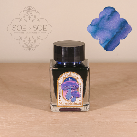 Ink bottle with mushroom design label on a wooden surface, featuring the brand 'SOE & SOE'.
