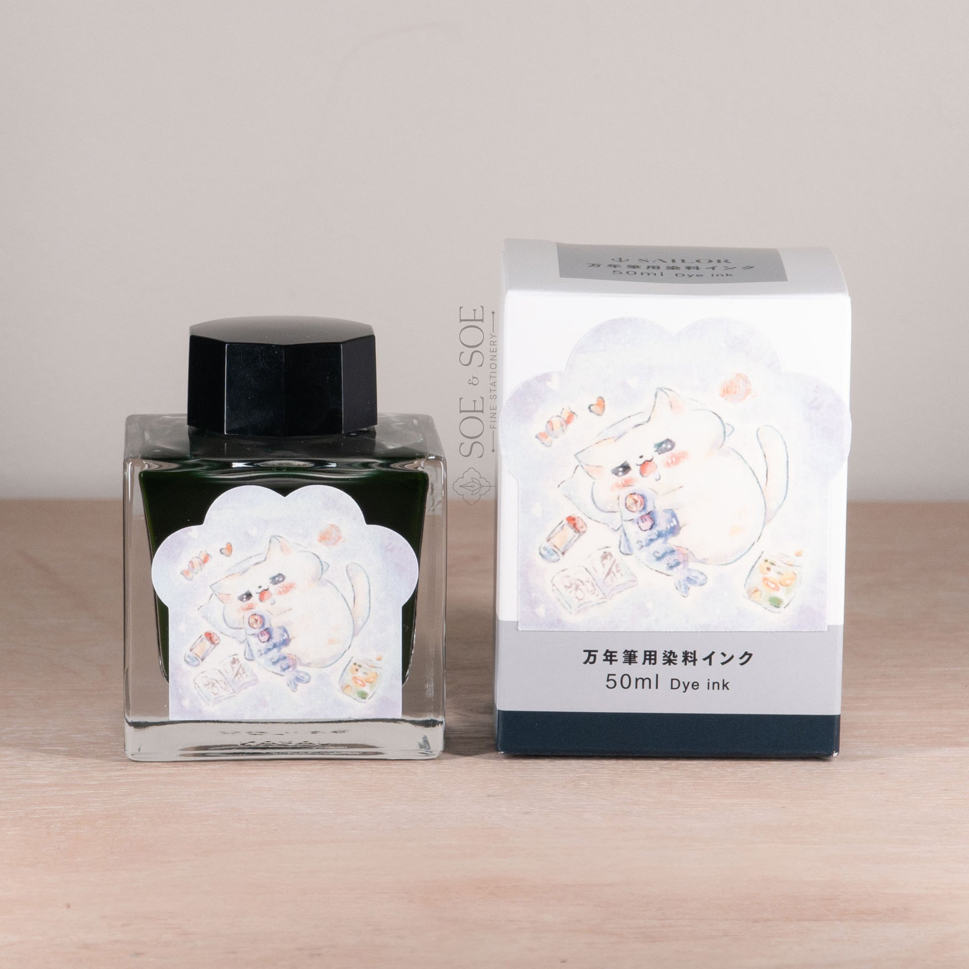 Ink bottle and packaging with happy chubby cat on a wooden surface