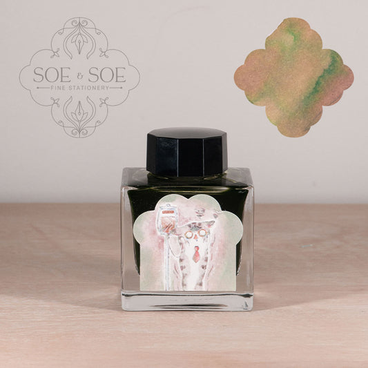 Ink bottle with label with chubby cat illustration on a wooden surface, featuring 'SOE & SOE' branding.