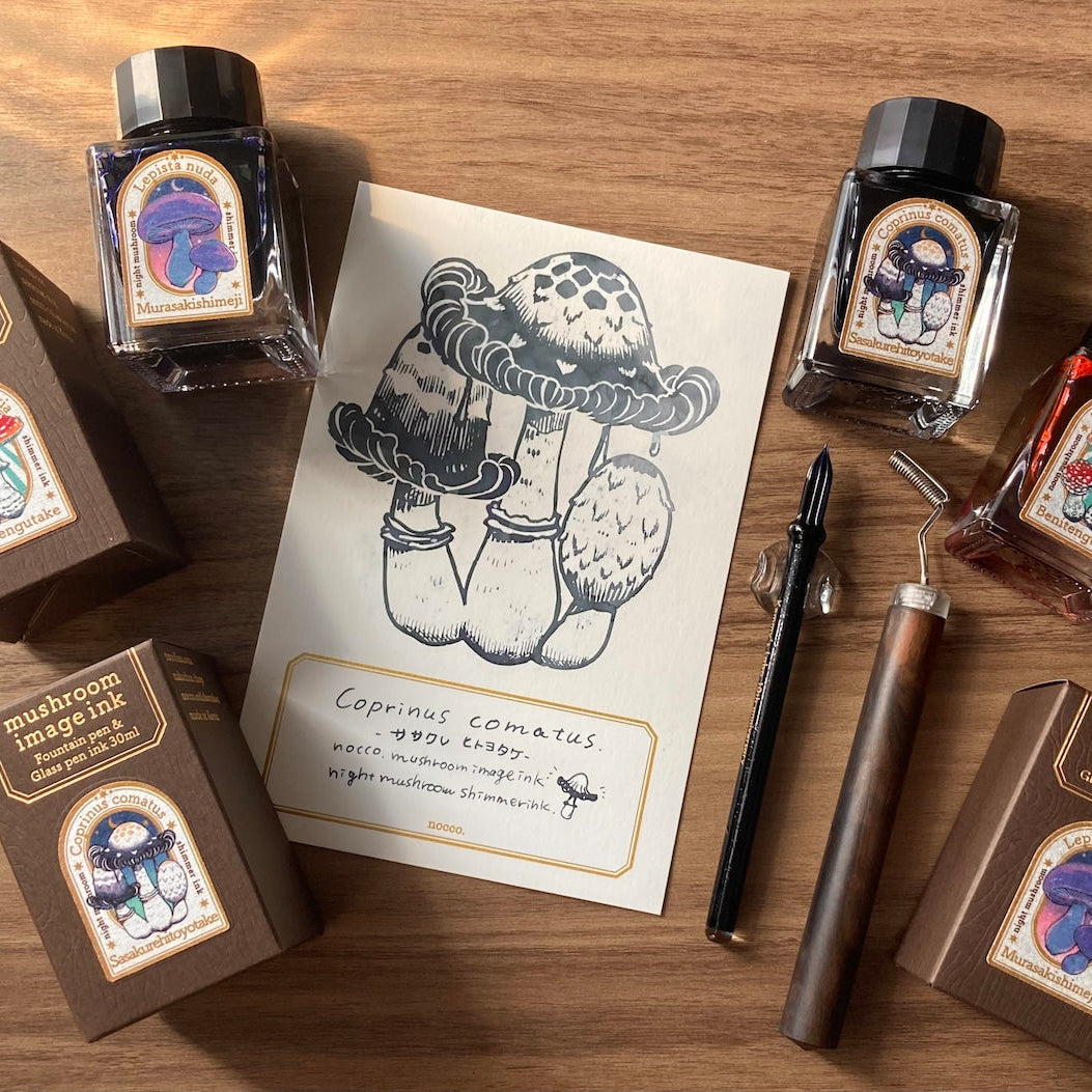 Mushroom-themed ink bottles and packaging on a wooden surface